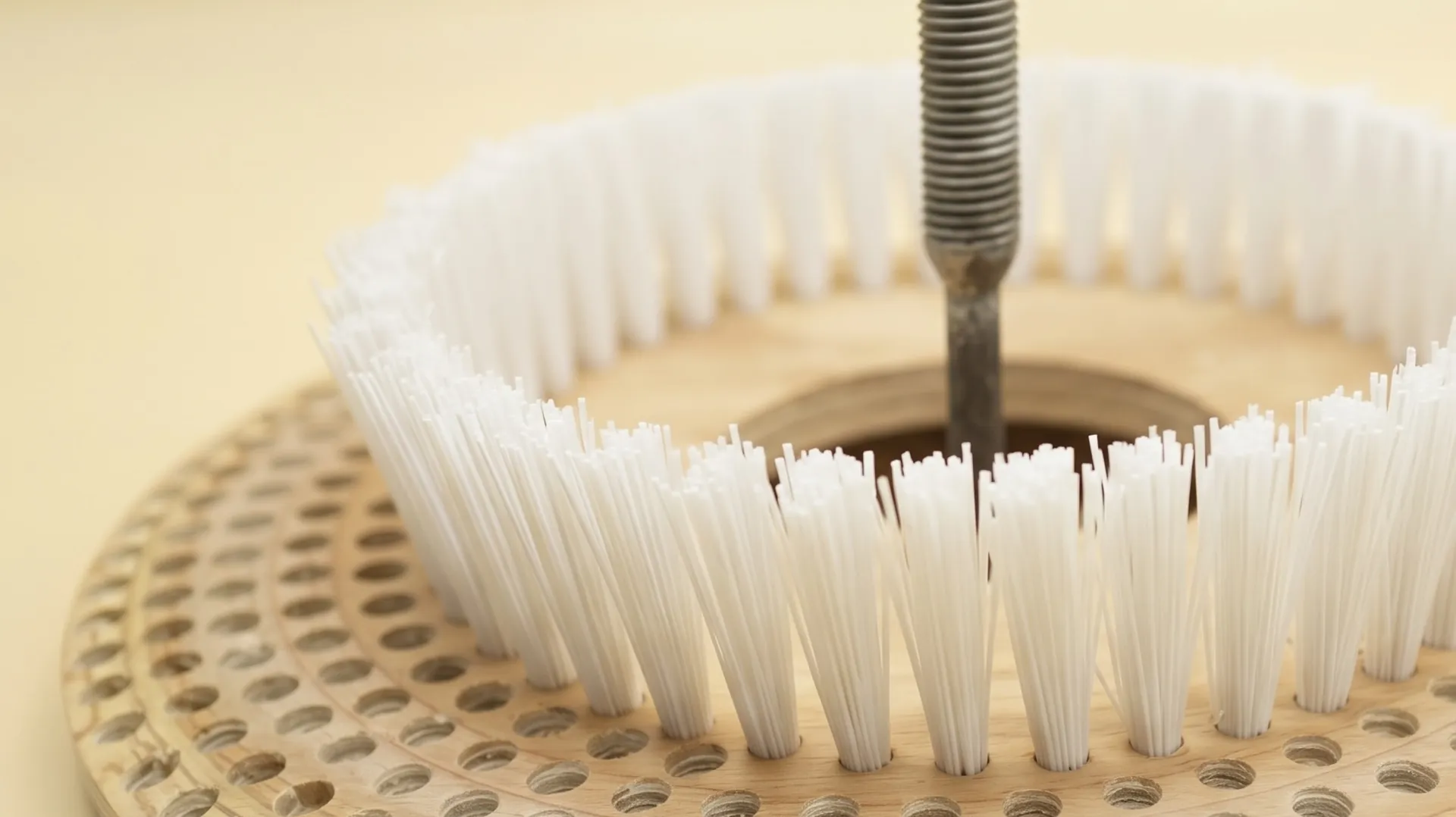 Base de madera de una escobilla con la fibra blanca colocada en el taller de Eveplast